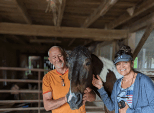people in barn with horse