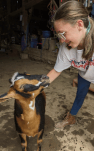 girl plays with goat